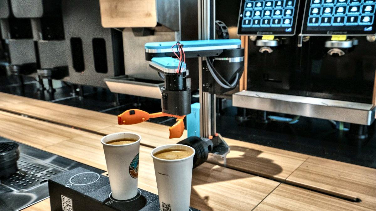 The arm setting two finished cups down on the counter