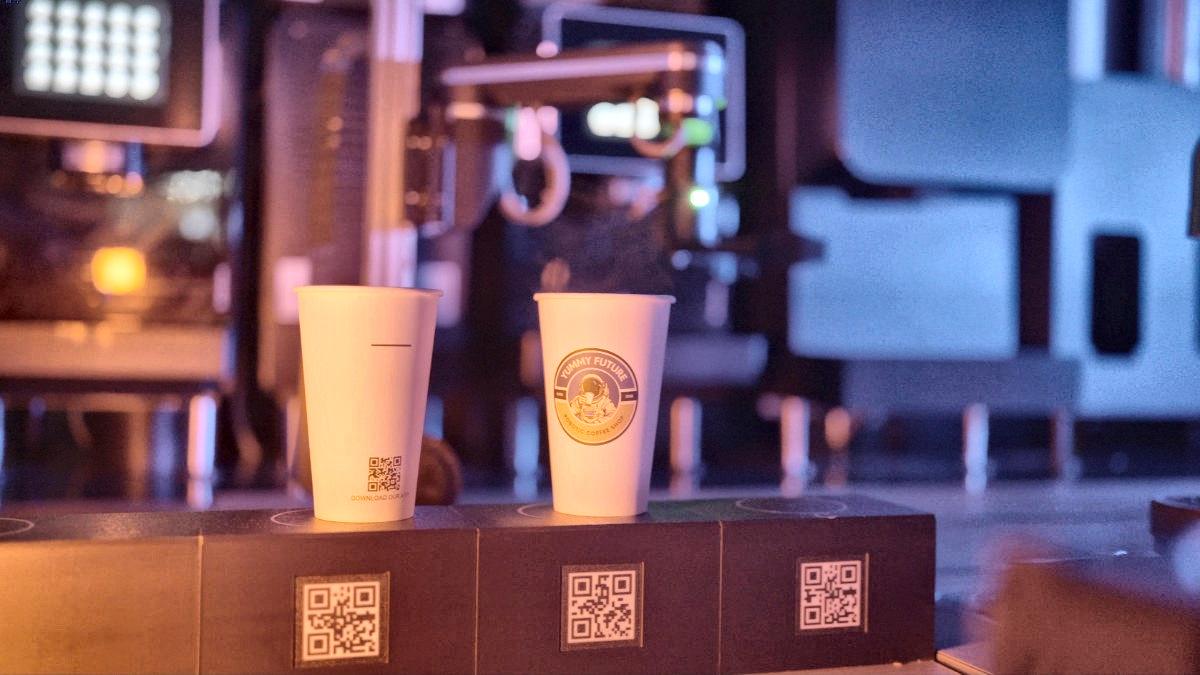 House cups lined up on the counter under the bar lights